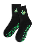 Black grip socks with green cannabis leaf embroidery and grips on a white background. Slip-resistant socks for pilates, barre, lagree or yoga.
